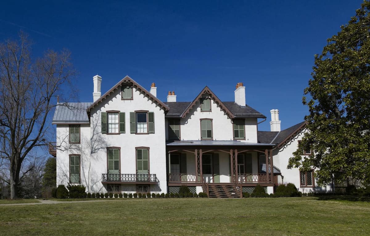 Gothic Revival gables and the veranda of President Lincoln's Cottage under a deep blue sky